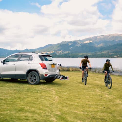 Dos personas montando bicicleta, cerca a un lago